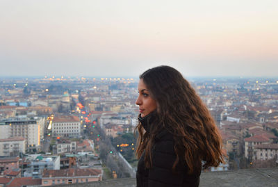 Close-up of a young woman overlooking cityscape