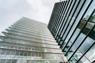 Low angle view of modern glass building against sky