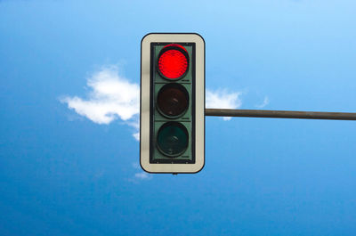 Low angle view of stoplight against blue sky