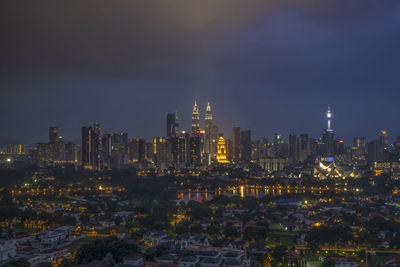 Illuminated buildings against sky at night