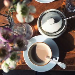 Directly above shot of coffee cup with flower vase on table