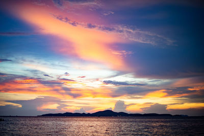 Scenic view of sea against dramatic sky during sunset