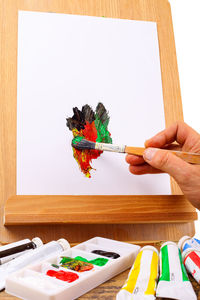 Person hand holding multi colored wooden table