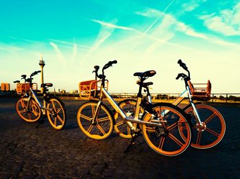 Bicycles parked on street against sky