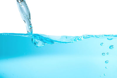 Close-up of water splashing against blue background