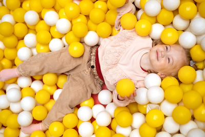 Funny cute little caucaisian blonde baby girl,toddler, smiling kid having fun in ball pool,playing