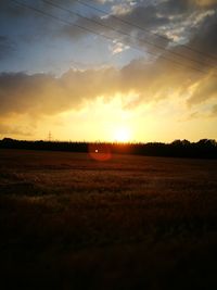 Scenic view of field against sky at sunset