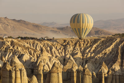 View of hot air balloon flying over mountain