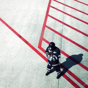 High angle view of man in uniform standing on road