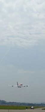 Cars on road against cloudy sky