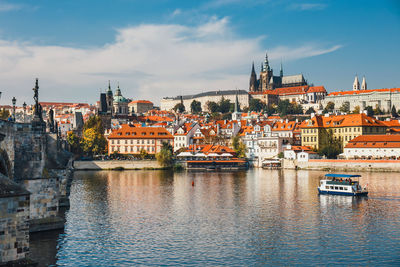 River amidst buildings in city against sky