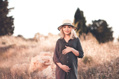 Pregnant woman standing in field