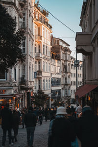 People walking on street amidst buildings in city