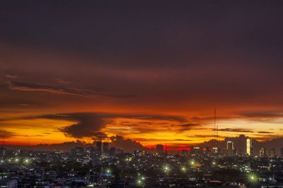 Illuminated buildings in city during sunset