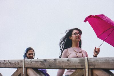 Portrait of young woman against clear sky