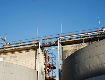 Low angle view of construction site against clear blue sky