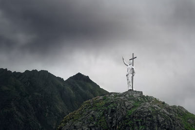 Low angle view of statue on rock against sky