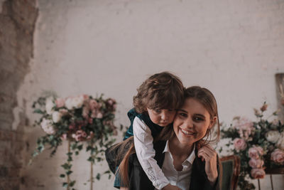 Portrait of a smiling young woman against wall