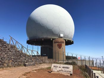 Low angle view of sign against clear blue sky