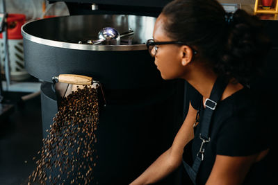 Side view of young woman working in cafe