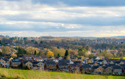 Houses by townscape against sky