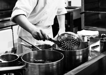 Midsection of man preparing food in kitchen