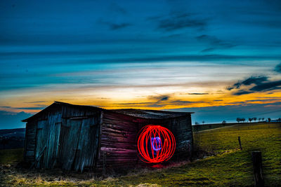 Barn on field against sky