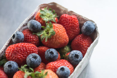 Close-up of strawberries and blueberries in cardboard container 