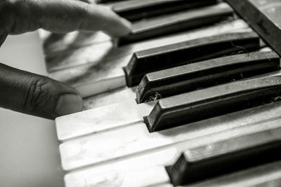 Close-up of hand holding piano