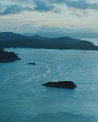 Scenic view of sea and mountains against sky