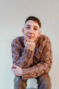 Portrait of smiling young woman against gray background