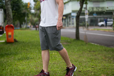 Low section of man standing on grass