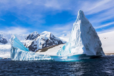 Scenic view of sea and snowcapped mountain against sky