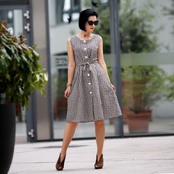 Woman in checked pattern dress standing on street