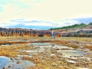 Man standing in water against sky