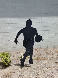 Rear view of silhouette woman walking on street