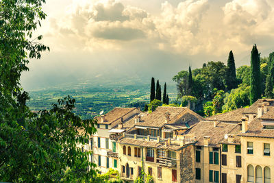 High angle view of buildings and trees against sky