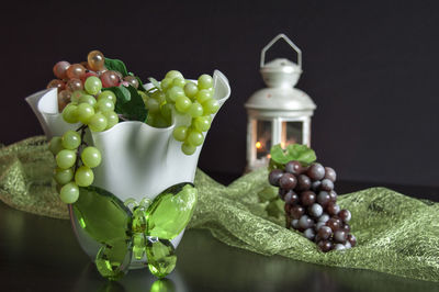 Close-up of grapes on table against black background
