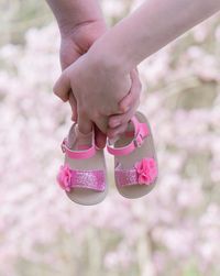 Cropped hand of couple holding baby sandal