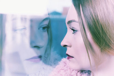 Close-up of young woman with reflection on glass