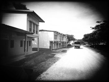 Empty road along buildings
