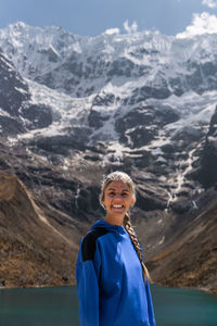 Portrait of young woman standing against mountain