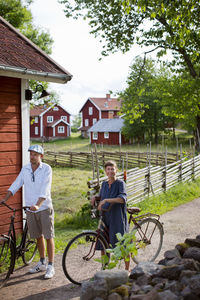 Man riding bicycle by house against building