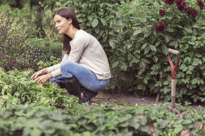 Full length side view of thoughtful woman working in organic farm