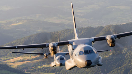 Airplane flying over mountains against sky