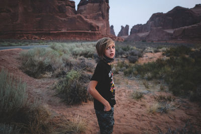 Portrait of young woman standing on rock