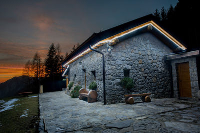 Illuminated mountain hut at sunset