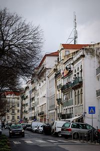 Cars on city street against sky