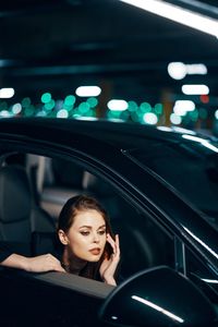 Portrait of young woman sitting in car