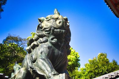 Low angle view of statue against clear blue sky